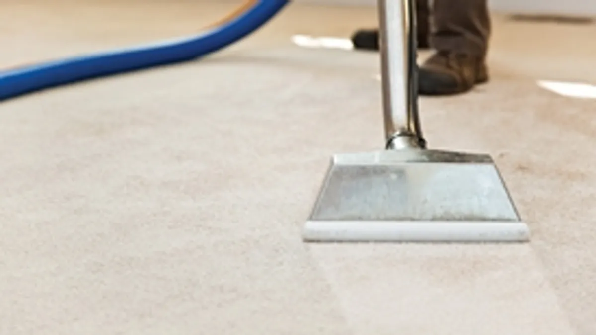 Carpet cleaning wand head gliding over a light carpet during hot-water extraction, Boise, ID.